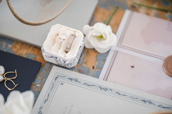 White rose flower and letters RSVP and wedding band rings in white box